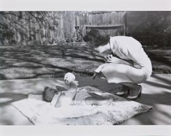 Mary Alwes with Michael McGregor in the backyard of an unidentified house, Santa Rosa, California, 1957