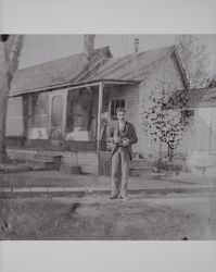 Man associated with the Judge Stephen Akers family stands with a camera in his hand, about 1900