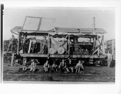 Men and boys surrounding a modified S.F.N.P. flat car