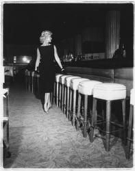 Black sleeveless dress modeled in the "Dramatic Moods" fashion show in the Topaz Room, Santa Rosa, California, 1959