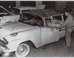 Kenneth R. Torliatt inspects damaged Souza family car, 132 Keller Street, Petaluma, California, January 1961