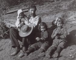 George Albert Titus and children sitting on the ground, Freestone, California, 1907