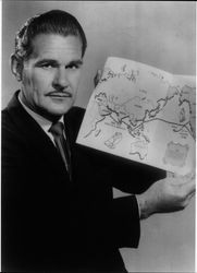 DeVere Baker holding a map of the Lehi IV's route across the Indian and Pacific oceans, about 1954