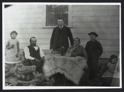 Unidentified family around a table outside their home