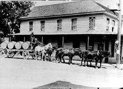 Team of horses hauling a wagon loaded with wine barrels