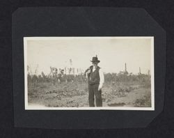 Unidentified man in a suit standing in a hop field