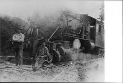 Three men at the front of a lumber train locomotive, June 13, 1914