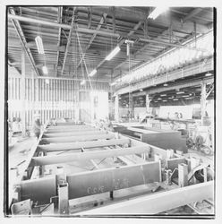 Workers prepare to lift a portable building base off a construction rack at Speedspace Corporation, 920 Shiloh Road, Windsor, California, 1971