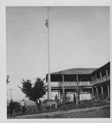 Man climbing up a flagpole at the Petaluma Adobe, Petaluma, California, about 1925