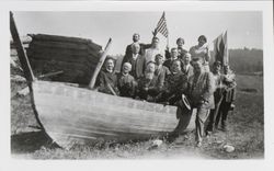 Native Sons of the Golden West from Sebastopol and Santa Ana sit in a wooden boat at Fort Ross ceremonies