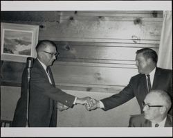 Jack W. Dei shaking hands with George Bath, photographed during the 1950s