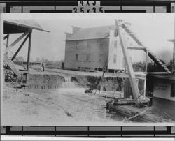 Girl and her father watch the Wilmington dredger make the new cut above the Washington Street bridge, Petaluma, California, 1914