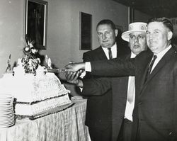 Jack Dei, Gene Benedetti and Francis "Frenchie" Mazza cutting a cake at the 50th anniversary celebration for the Petaluma Cooperative Creamery, 1963