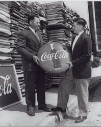 Kresky Sign representative presents a Coca Cola sign to a Coke representative