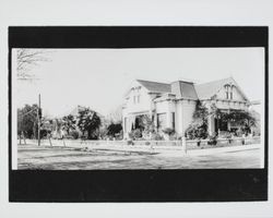 Two-story Queen Anne Victorian house on the corner of a dirt street in an unidentified Sonoma County, California, location, early 1900s