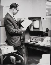 Tom Dunn using a microfilm reader/printer at the library on Exchange Avenue