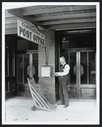 Postmaster Thomas Wilson opening mail box outside of Cloverdale Post Office