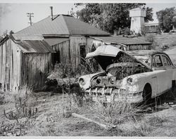 Dilapidated farm cottage and a derelict Oldsmobile, Sonoma County, California, 1950s