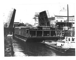 Tugboat "Golden Eagle" towing a barge underneath the Washington Street bridge, Petaluma, California, about 1938