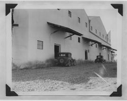 Two model A cars parked outside the Poultry Producers of Central California feed mill in Petaluma, about 1938