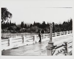 Man standing on bridge at Guerneville with Russian River at flood stage