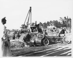 Tow truck separating a pile of wrecked racing cars