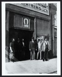 Men standing outside the Sunrise Shoeing Parlor