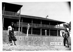 Miss Sonoma County and Ron O'Donnell posing with the Old Adobe Days Fiesta sign, Petaluma, California, August, 1963