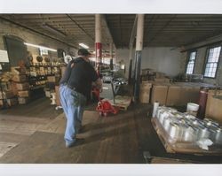 Big Dennis Henderson pushes a pallet jack loaded with a piece of machinery at Sunset Line & Twine Company in Petaluma, California, Dec. 2006