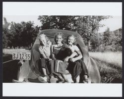 Mary McGregor and two unidentified girls sitting in the trunk of a car, Santa Rosa, California, about 1938