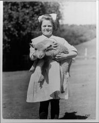 Girl carrying a lamb at the Lytton Home (the Salvation Army Boys and Girls Industrial Home and Farm in Lytton, California)