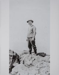 Octavius G. Wood stands on a rock in Montana, likely 1890s