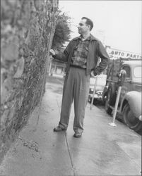 Unidentified man measuring the Hill Plaza Park wall, Petaluma, California, 1958