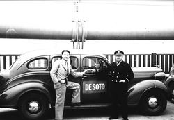 Petaluma Fire Chief Lucien Benoit shaking hands with Irv Rohner, state highway patrolman, while standing near a DeSoto car on the Golden Gate Bridge, May 26, 1937