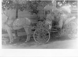 Blue larkspur and white roses decorate carriage carrying Clara and Martha Hahman, Bess Riley, and Mildred Turner