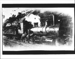 Two men standing next to a locomotive, Petaluma, California, 1910