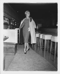 Model in evening dress and a long coat in the "Dramatic Moods" fashion show in the Topaz Room, Santa Rosa, California, 1959