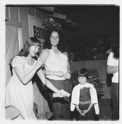 Bank of Marin representative holding a pair of raffle tickets in the Bank of Marin booth at the Sonoma-Marin Fair, Petaluma, California, 1978