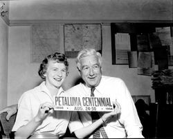 Two people holding a Petaluma Centennial sign