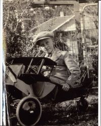 Henry A. Peoples seated in a toy airplane in his backyard at 523 Oak Street, Petaluma, California, about 1926