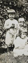 Wilfred Everett Bixby, Jr. eating an apple with two unidentified children at the Bixby house, 415 Perkins Street, Oakland, California, about 1912