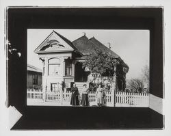 Three women stand outside a two-story Queen Anne Victorian house in an unidentified Sonoma County, California, location, 1890s