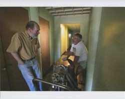 John Agnew and Hal Janssen at the Sunset Line & Twine Company in Petaluma, California, standing in the hallway next to a piece of machinery that will be moved into a vehicle, Dec. 5, 2006