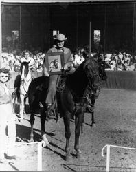 Elaine Rossi, member of the 1946 California Centaurs, at the Boyes Hot Springs Horse Show, holding a trophy for 1st place all around cowboy champion