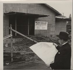 Reverend Hartzel examining blueprints for Saint John's Episcopal Church social hall and classroom addition, Petaluma, California, about 1964