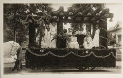 Rose Carnival float holding women in white with live doves