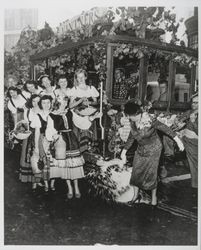 Mrs. Beringer breaking a bottle of wine on a grape vine decorated cable car