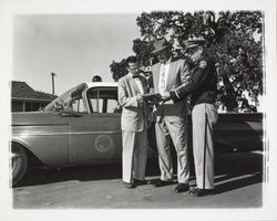 Dutch Flohr and two others standing near a City of Santa Rosa car, Santa Rosa, California, 1959