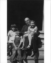 Walter S. Neil seated on the steps of 231 Wilson Street, Petaluma, California with his daughter, niece and nephew, about 1927