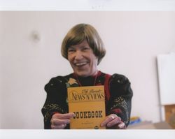 Mary Graham, office manager of Sunset Line & Twine Company in Petaluma, California, holding up a cookbook on Dec. 22, 2006, during the farewell party